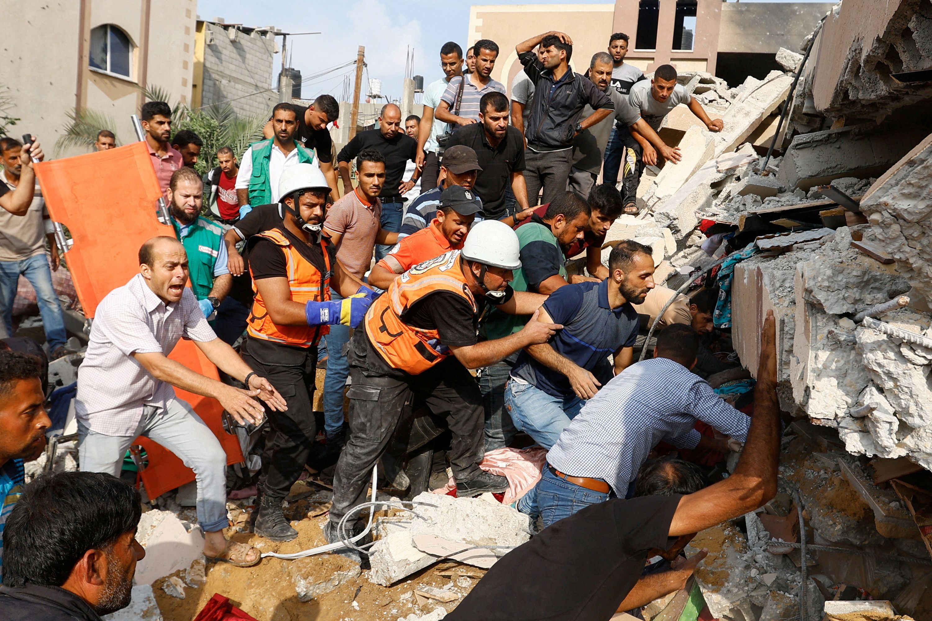 Palestinians search the rubble of a home in Khan Younis that was destroyed by Israeli airstrikes on October 8.