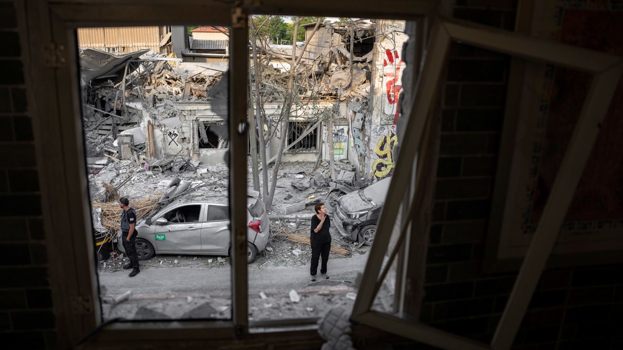 Les Israéliens inspectent les décombres d’un bâtiment un jour après qu’il a été touché dimanche par une roquette tirée depuis la bande de Gaza, à Tel Aviv, en Israël. 