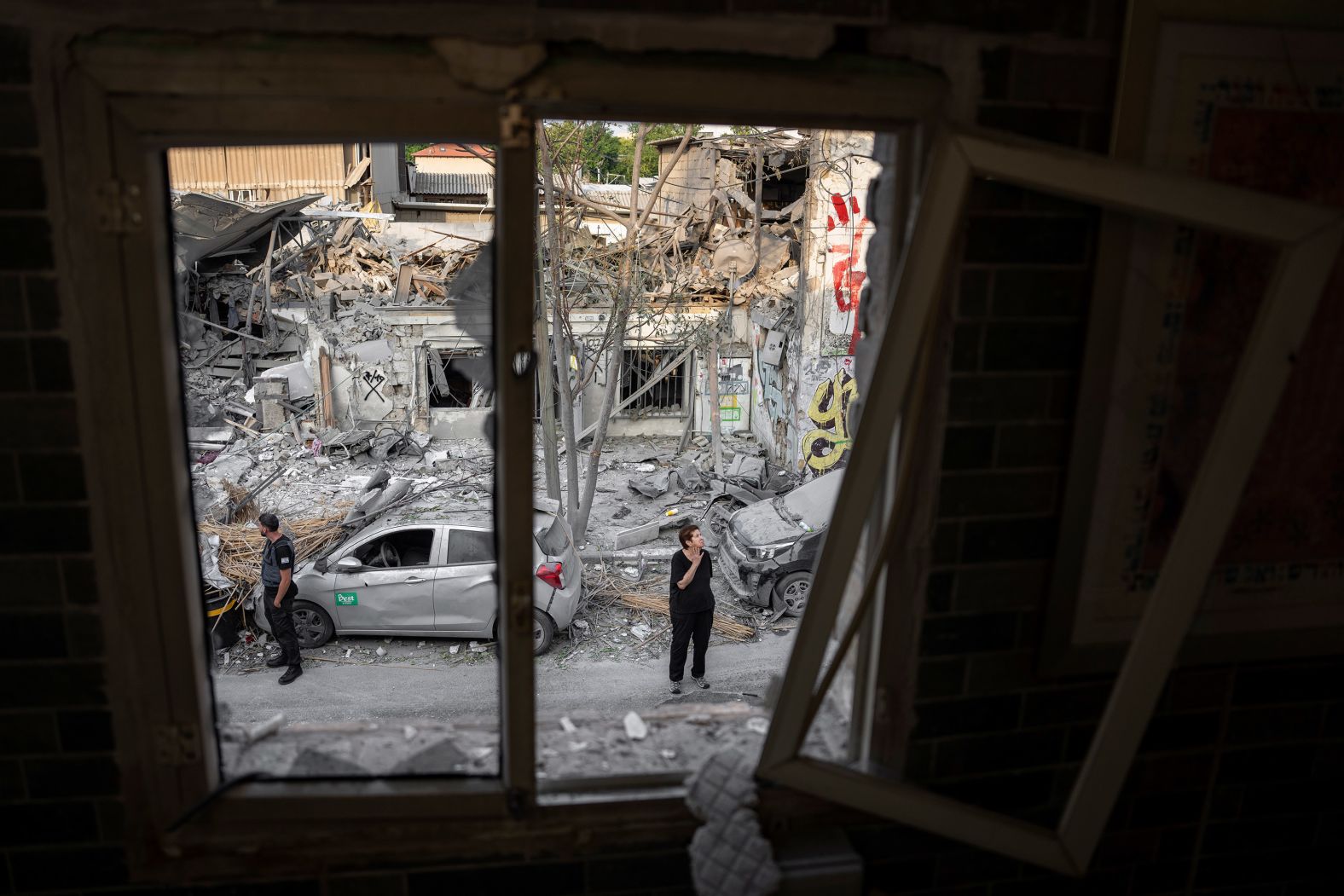 Israelis inspect the rubble of a building in Tel Aviv on October 8, a day after it was hit by a rocket fired from Gaza.