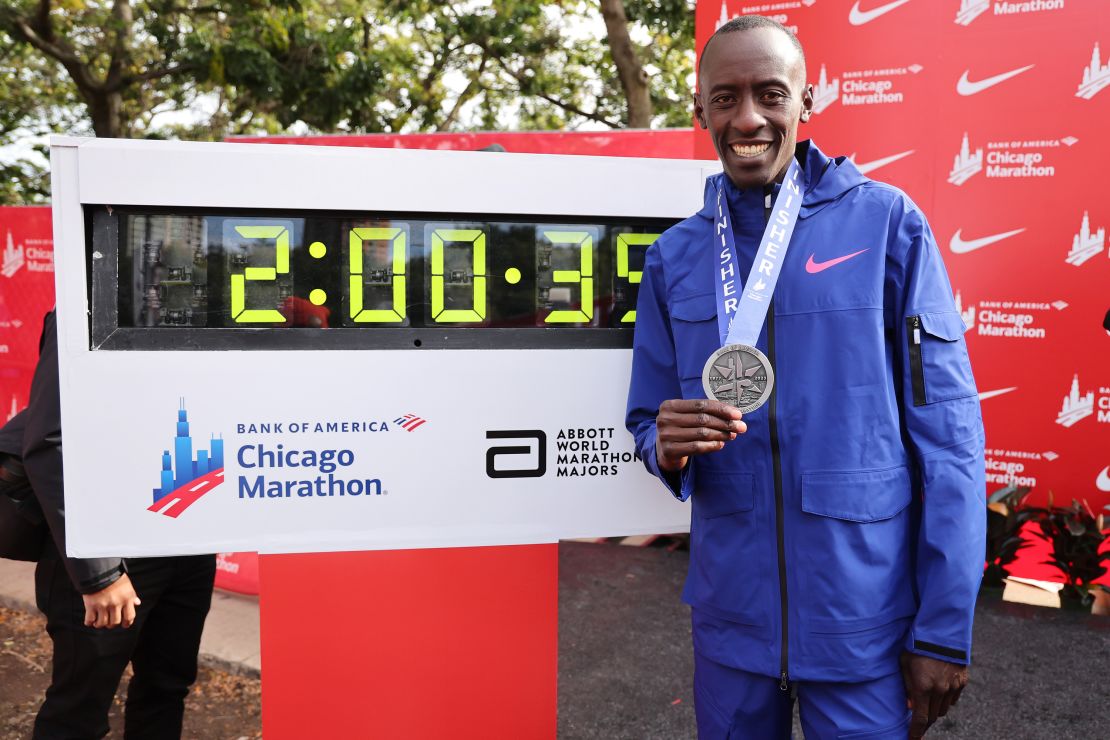 CHICAGO, ILLINOIS - OCTOBER 08: Kelvin Kiptum of Kenya poses with his medal and the clock after setting a world record marathon time of 2:00.35 during the 2023 Chicago Marathon on October 08, 2023 in Chicago, Illinois. (Photo by Michael Reaves/Getty Images)