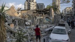 Израелци инспектират руините на постройка ден откакто тя беше ударена от ракета, изстреляна от Ивицата Газа, в Тел Авив, Израел, неделя, 8 октомври 2023 година Войнстващите водачи на Хамас в Ивицата Газа направиха невиждана, многофронтова офанзива против Израел призори в събота, изстрелвайки хиляди ракети, до момента в който десетки бойци на Хамас проникнаха през мощно укрепената граница на няколко места по въздух, суша и море, убивайки стотици и пленявайки. Палестинските здравни чиновници оповестиха за десетки смъртни случаи от израелските въздушни удари в Газа. 