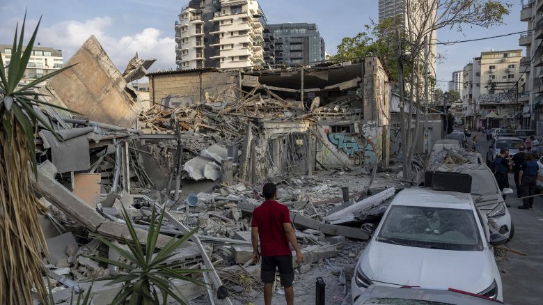 Israelis inspect the rubble of a building a day after it was hit by a rocket fired from the Gaza Strip, in Tel Aviv, Israel, Sunday, Oct. 8, 2023. The militant Hamas rulers of the Gaza Strip carried out an unprecedented, multi-front attack on Israel at daybreak Saturday, firing thousands of rockets as dozens of Hamas fighters infiltrated the heavily fortified border in several locations by air, land, and sea, killing hundreds and taking captives. Palestinian health officials reported scores of deaths from Israeli airstrikes in Gaza. 