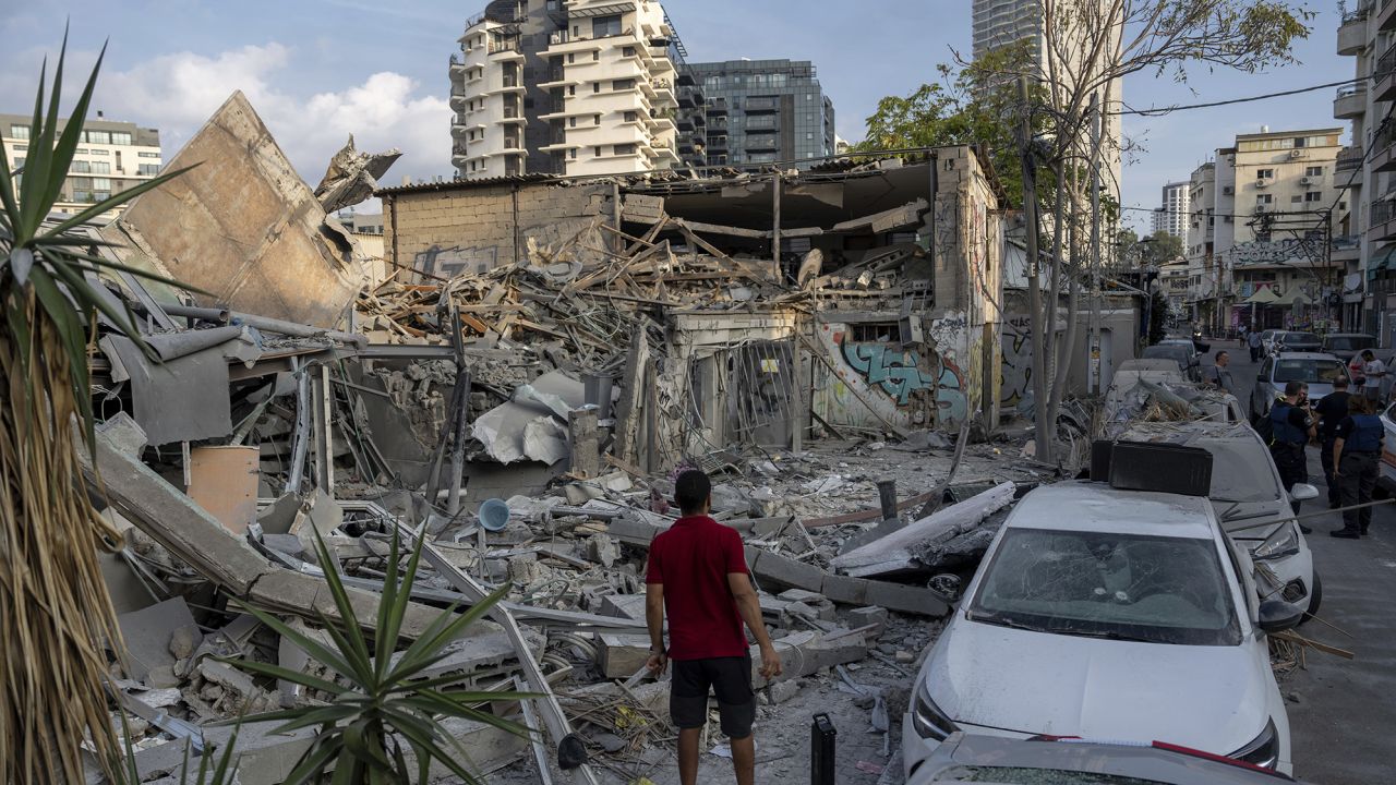 Los israelíes inspeccionan los escombros de un edificio un día después de que fuera alcanzado por un cohete disparado desde la Franja de Gaza, en Tel Aviv, Israel, el domingo.