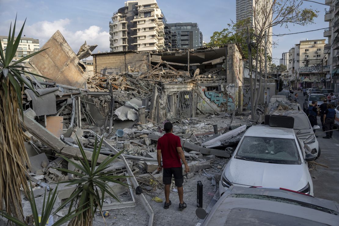Israelis inspect the rubble of a building a day after it was hit by a rocket fired from the Gaza Strip, in Tel Aviv on October 8, 2023.