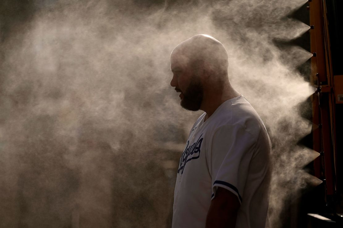 A man cools off in a mister at Kauffman Stadium as temperatures approach 100 degrees fahrenheit before a baseball game between the Kansas City Royals and the Cleveland Guardians on June 28, 2023, in Kansas City, Missouri. 