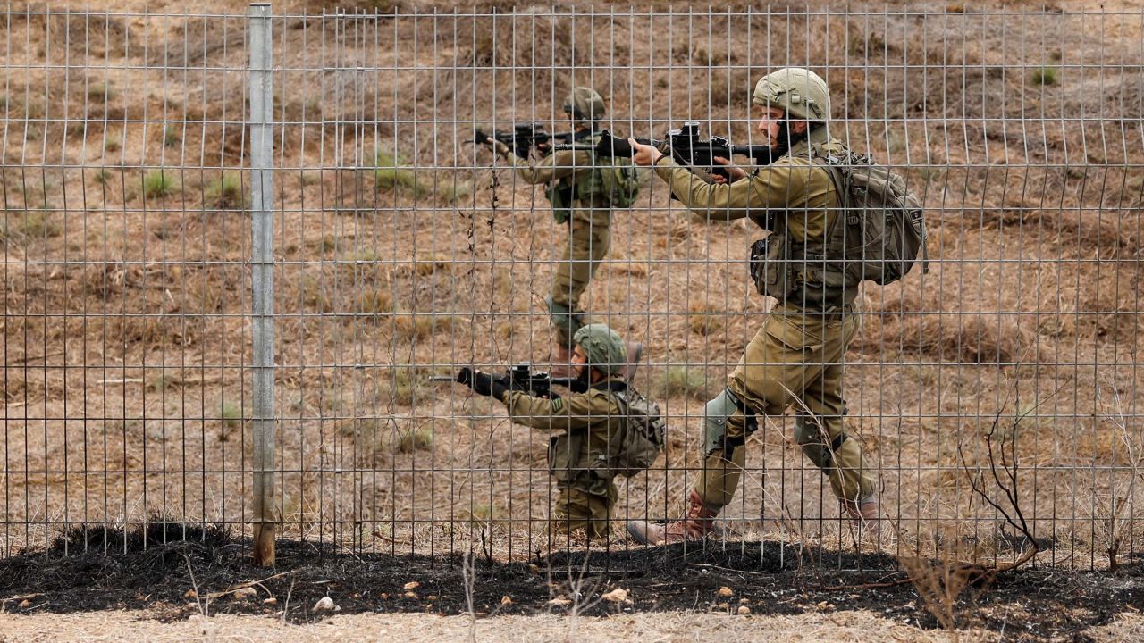 Israeli soldiers scan an area as rockets from Gaza are launched towards Israel, near Sderot in southern Israel on Monday.