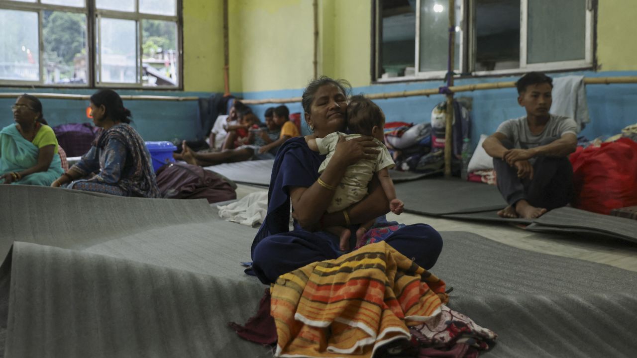 A woman holds a child inside a relief shelter after flash floods, caused by a lake burst in Singtam, Sikkim, India, October 8, 2023. 