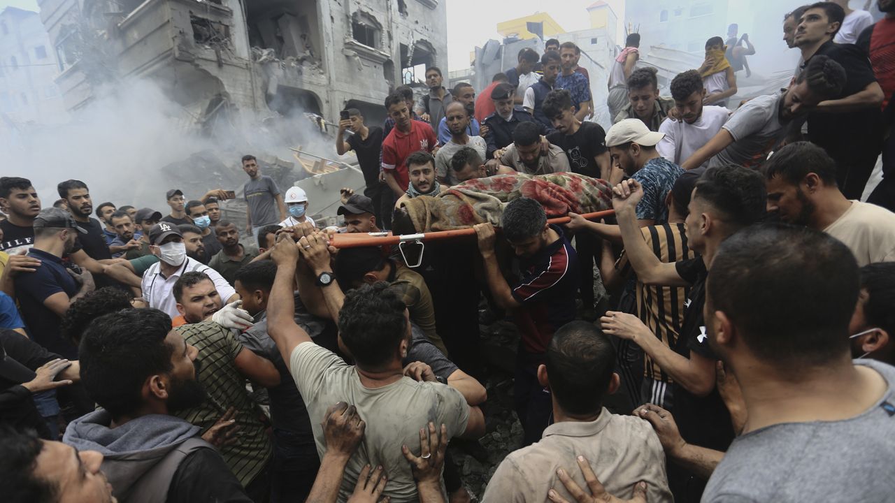 Palestinians remove a dead body from the rubble of a building after an Israeli airstrike hits Jebaliya refugee camp, in the Gaza Strip on Monday.