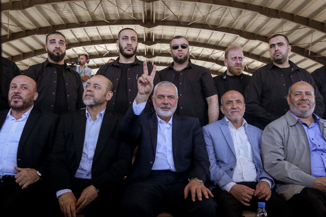 Ismail Haniyeh, center, chairman of the Hamas political bureau, flashes a victory sign, flanked by bodyguards and senior Palestinian officials during a rally at the southern Lebanese port city of Sidon.