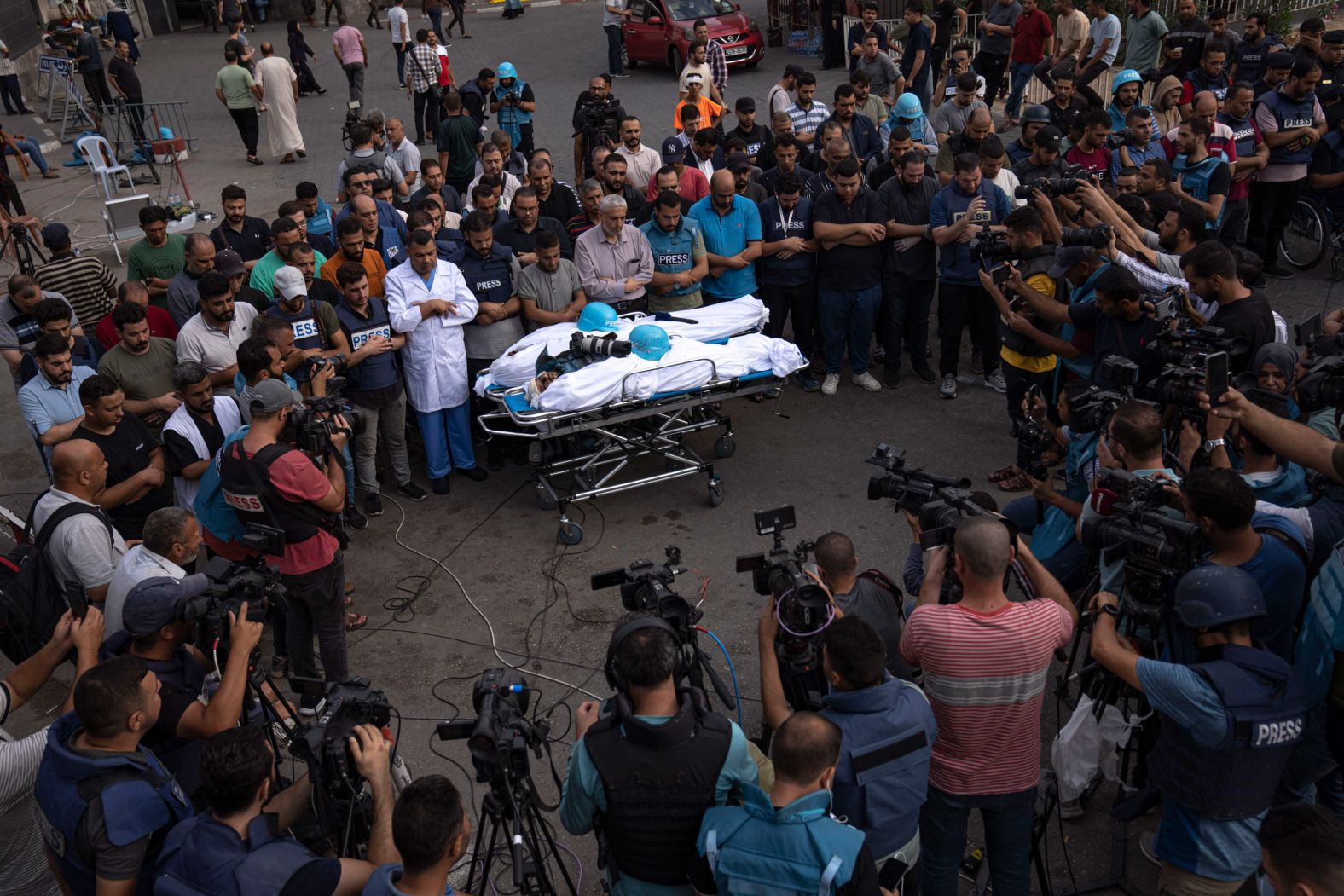 People gather around the bodies of two Palestinian reporters, Mohammed Soboh and Said al-Tawil, who were killed by an Israeli airstrike in Gaza City on Tuesday, October 10.