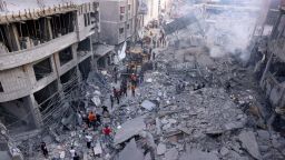 Палестинските цивилни и спасители оказват помощ за разчистването на руините в мощно бомбардирания център на град Хан Юнис в южната част на Газа след нощния израелски обстрел на 10 октомври 2023 г.
