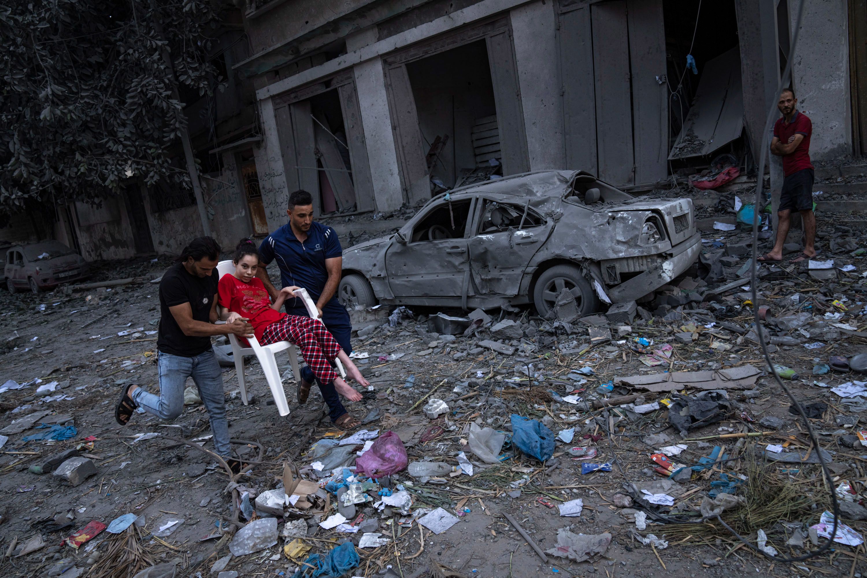 Palestinians walk amid the rubble following Israeli airstrikes in Gaza City on October 10.