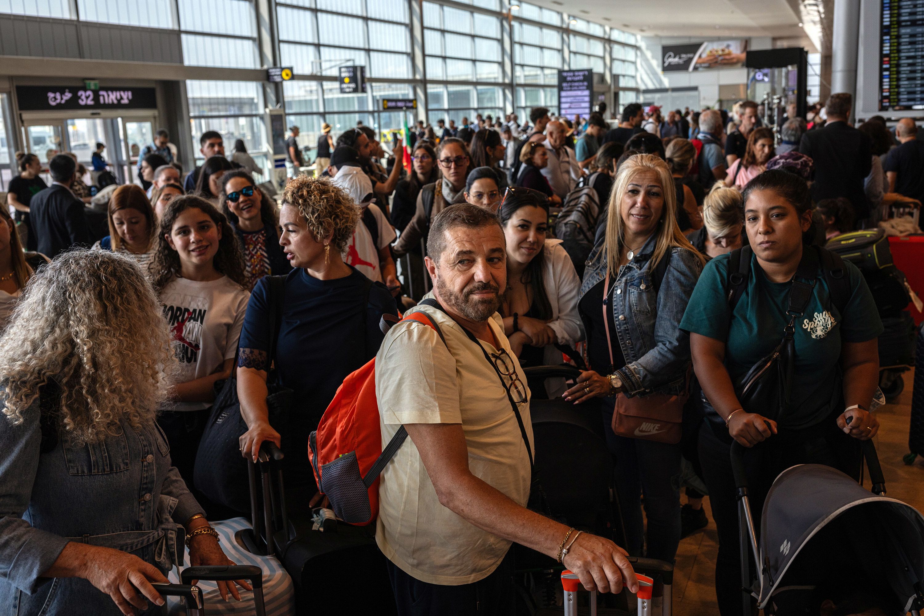 Stranded travelers wait to be booked on a flight at Ben Gurion International Airport outside Tel Aviv on October 10.