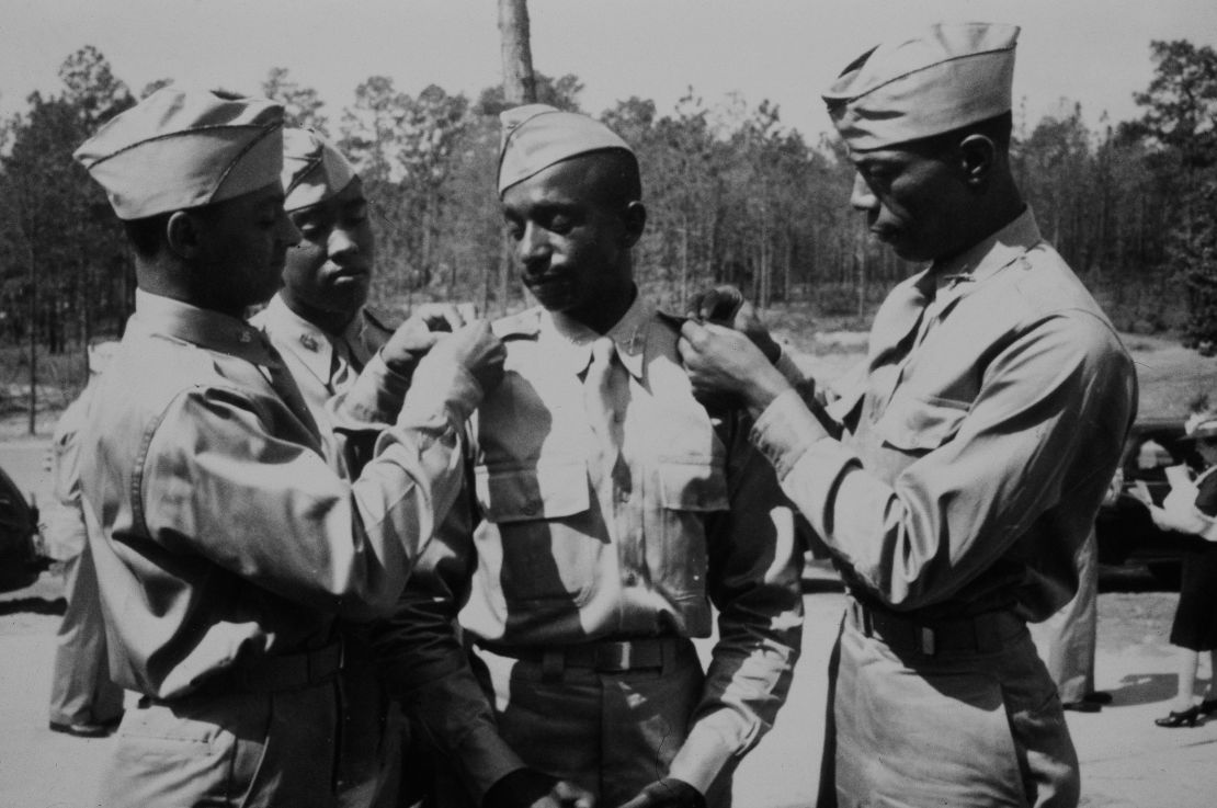 American military officers Second Lieutenant Henry C Harris, Jr, Second Lieutenant Rogers H Beardon, Second Lieutenant Frank Frederick Doughton, and Second Lieutenant Elmer B Kountze start pinning their brass bars on each other's shoulders after stepping out of Theater No 4 at the conclusion of the 16th Officer Candidate School graduating ceremony at Fort Benning, Georgia, 29th May 1942. (Photo by Archive Photos/Getty Images)