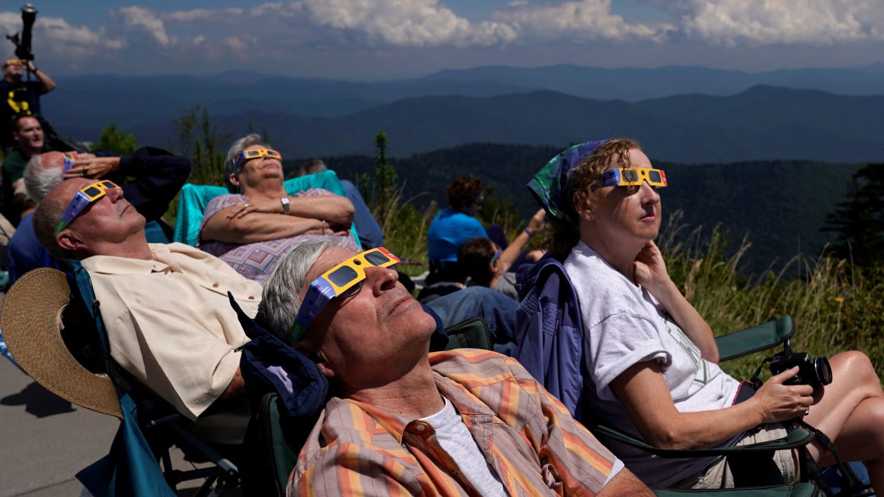 Хората гледат до момента в който слънчевото затъмнение се доближава към цялостното от Национален парк Great Smoky Mountains, Тенеси, на 21 август 2017 година class=