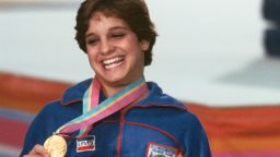  Носителката на златен орден Мери Лу Ретън театралничи за фотография след церемонията по награждаването за съчетанието по гимнастика за дами на Летните олимпийски игри в Лос Анджелис през 1984 година 