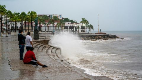 Men observe waves crashing against an ocean pier as Hurricane Lidia barrels towards Mexico's Pacific coast, in Puerto Vallarta, Mexico October 10, 2023.