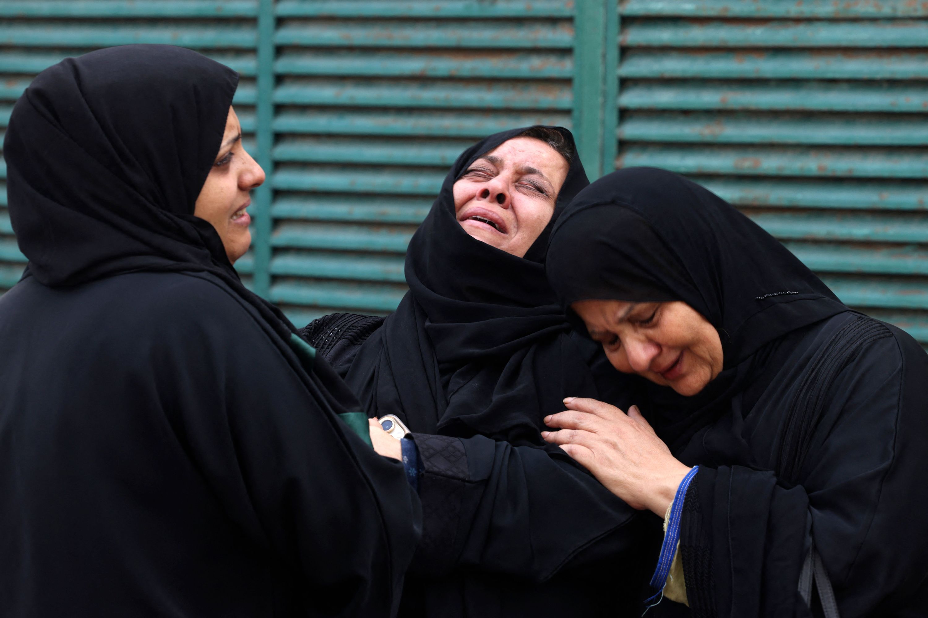Palestinians mourn during the funeral of a relative killed in an Israeli strike, in Gaza City on October 10.