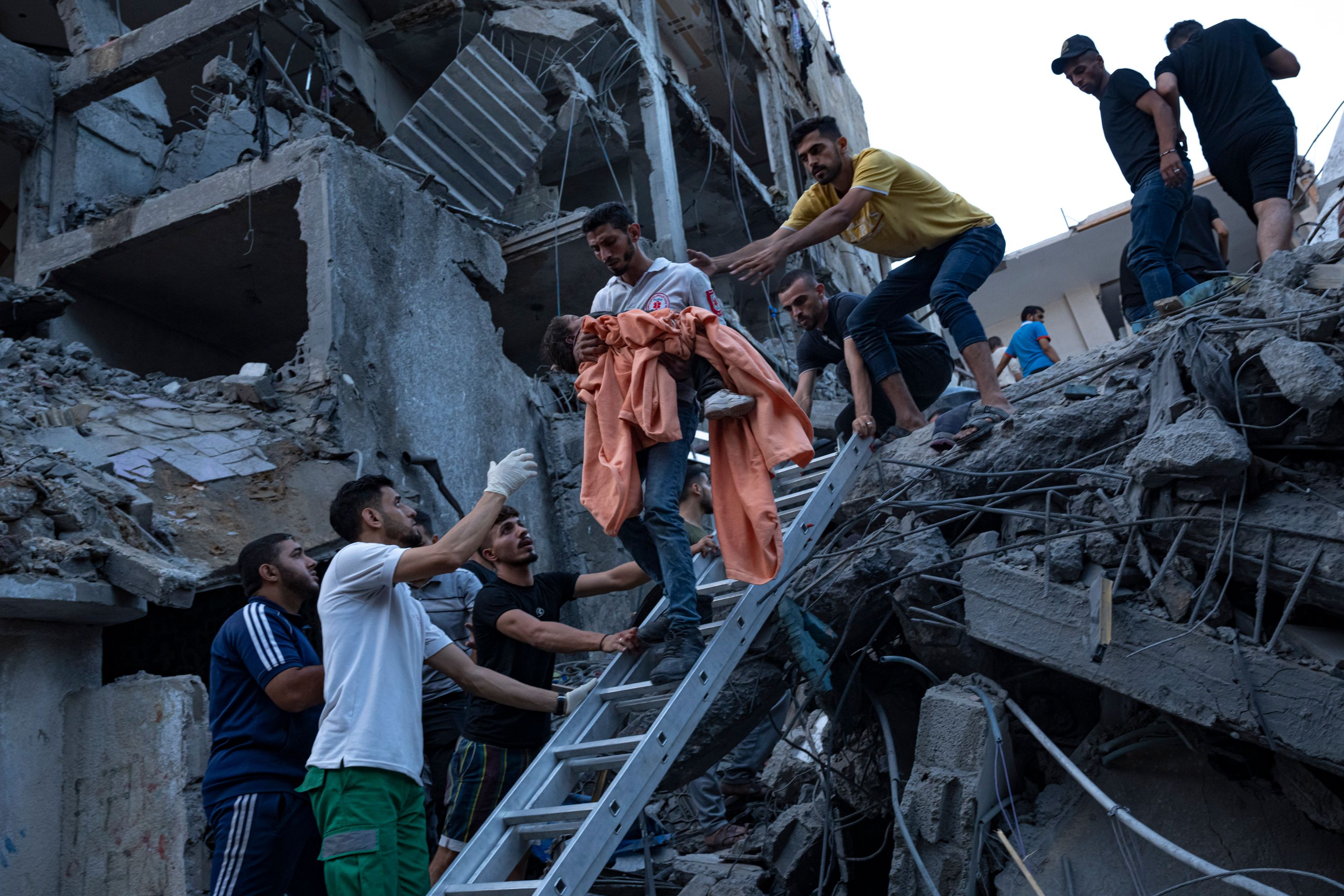 Palestinians rescue a young girl from the rubble of a destroyed residential building following an Israeli airstrike on October 10.