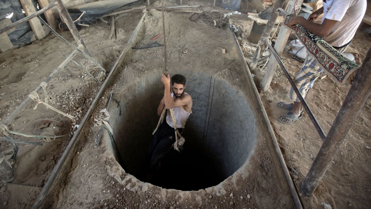 A Palestinian man is lowered into a smuggling tunnel beneath the Gaza-Egypt border, in the southern Gaza Strip, on September 11, 2013. 