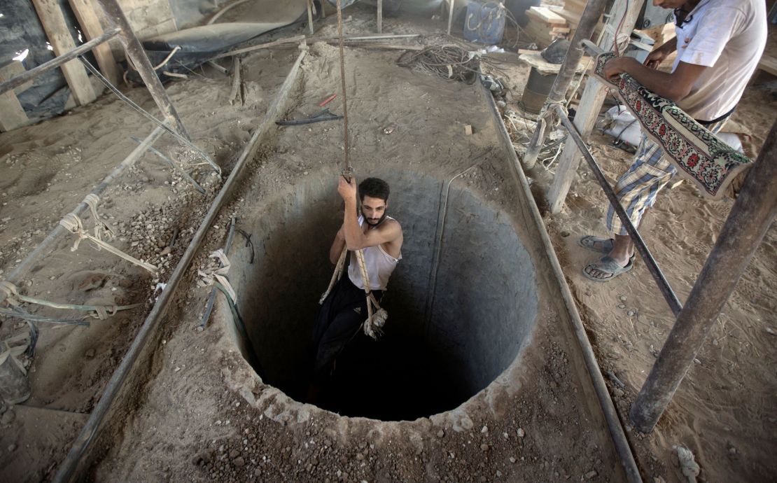 A Palestinian man is lowered into a smuggling tunnel beneath the Gaza-Egypt border, in the southern Gaza Strip, on September 11, 2013. 