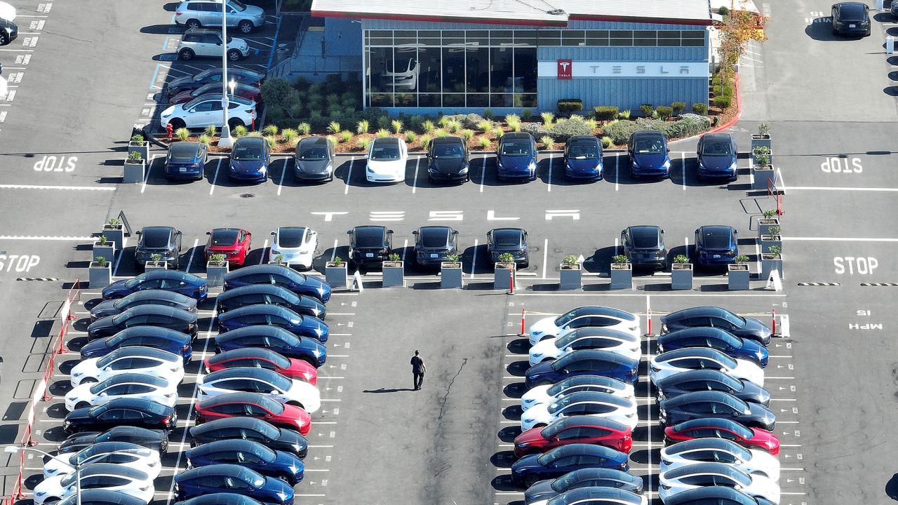 In an aerial view, brand new Tesla cars sit in a parking lot at the Tesla factory on October 19, 2022 in Fremont, California. 