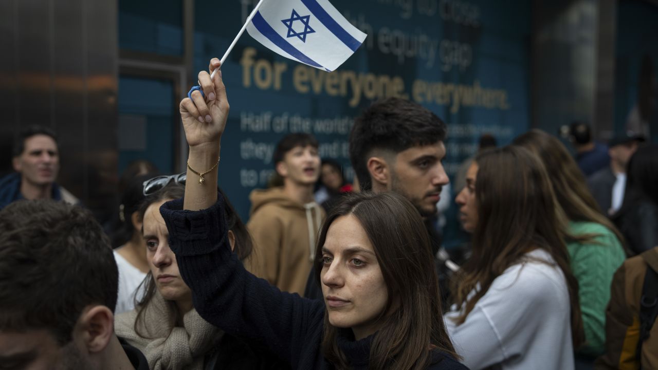 A person holds an Israeli flag as opposing groups protest near the Israeli consulate in New York City on October 8.