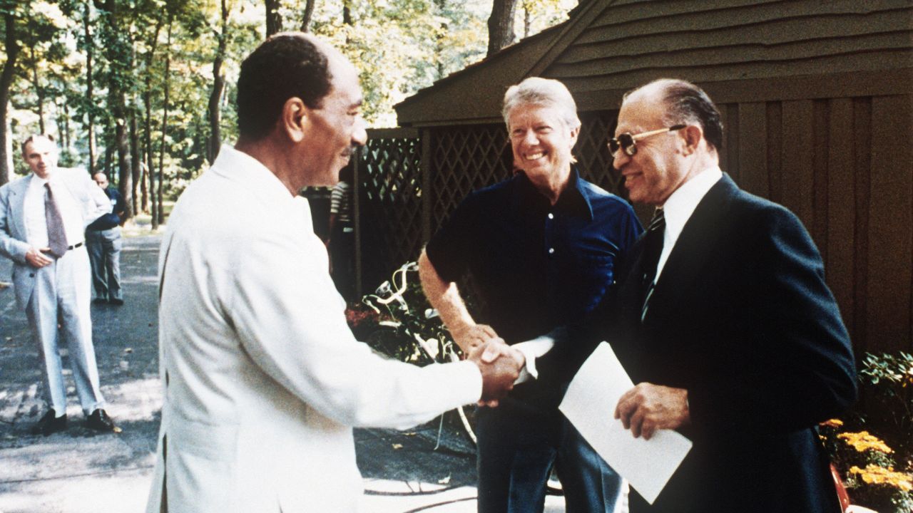 Carter watches as Egyptian President Anwar al-Sadat shakes hands with Israel's Menachem Begin at Camp David in 1978.