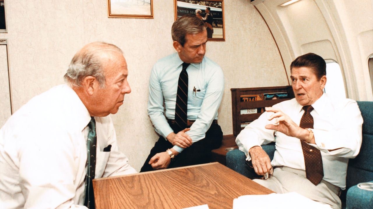 Secretary of State George Shultz and National Security Advisor-designate Robert McFarlane listen to Reagan speak about the ongoing issues in Beirut on Air Force One on October 23, 1983.