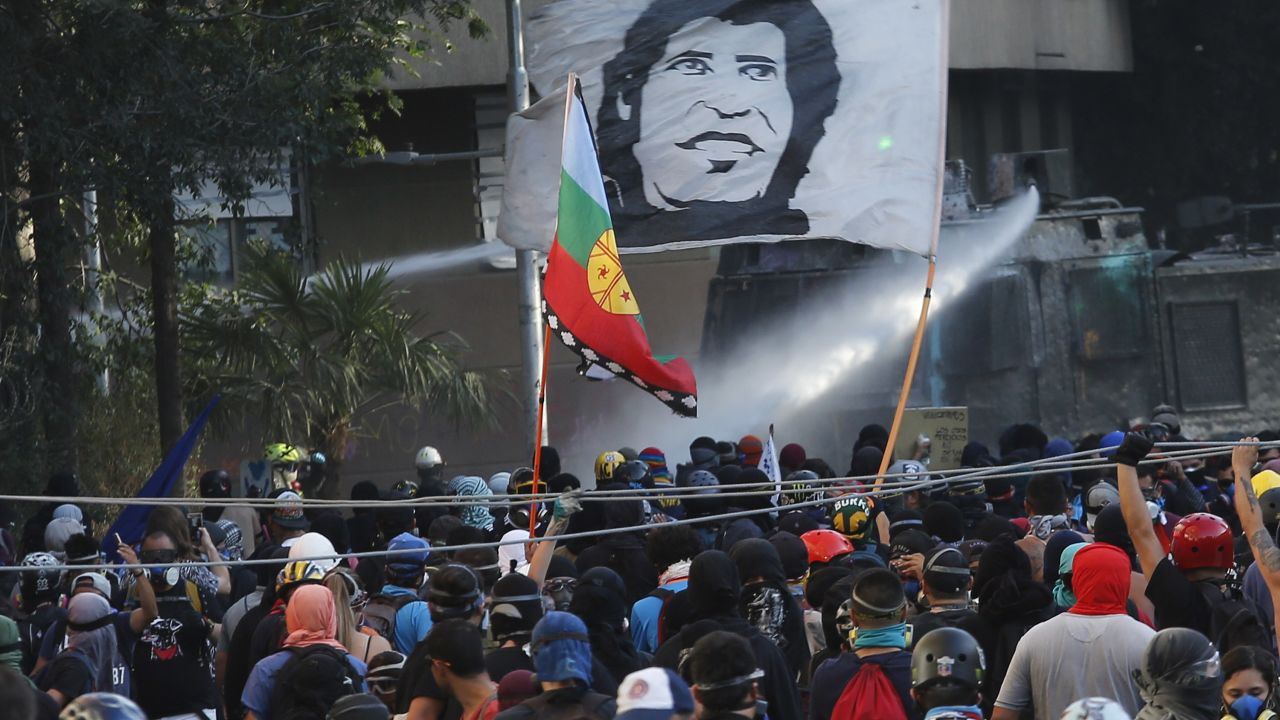 Demonstrators carry a flag with Victor Jara's image during a protest against the Chilean government in January 2020.