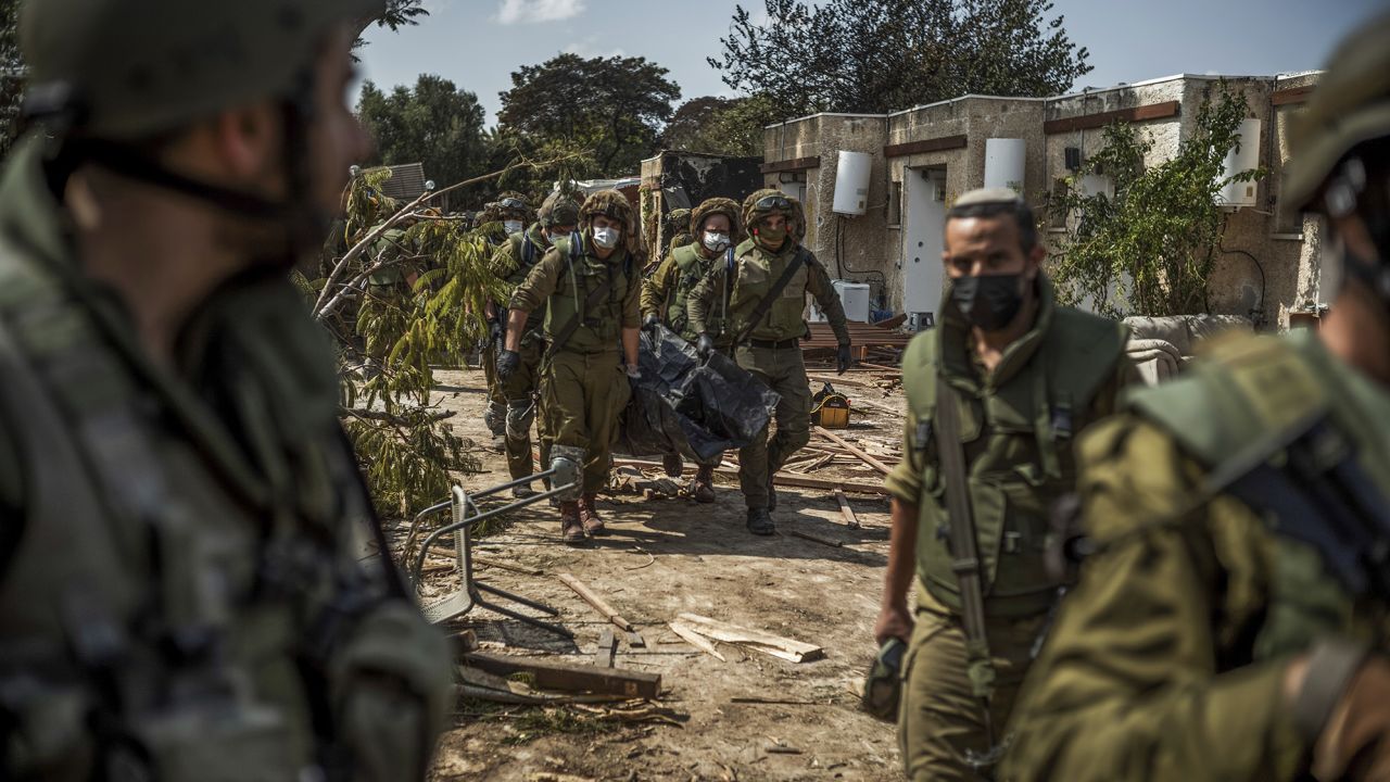 Israeli forces extract dead bodies of Israeli residents from a destroyed house in Kfar Aza on Tuesday.