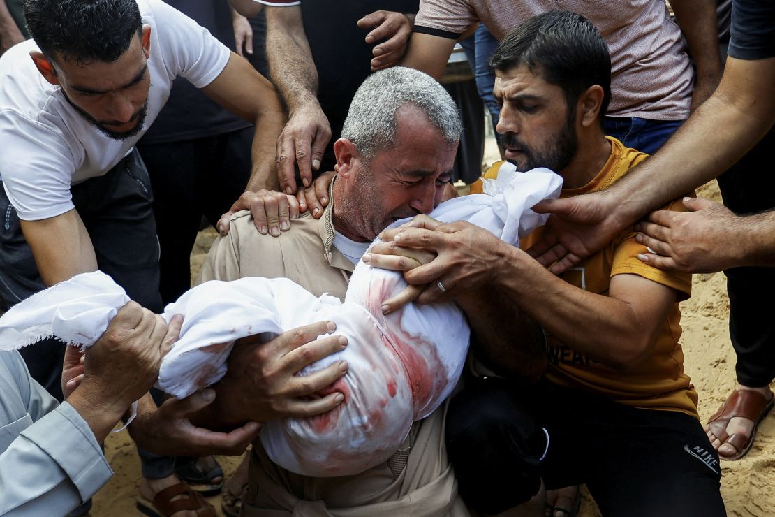 A mourner reacts while burying a child from who was killed in Israeli strikes in Khan Younis, Gaza, on October 11, 2023. 
