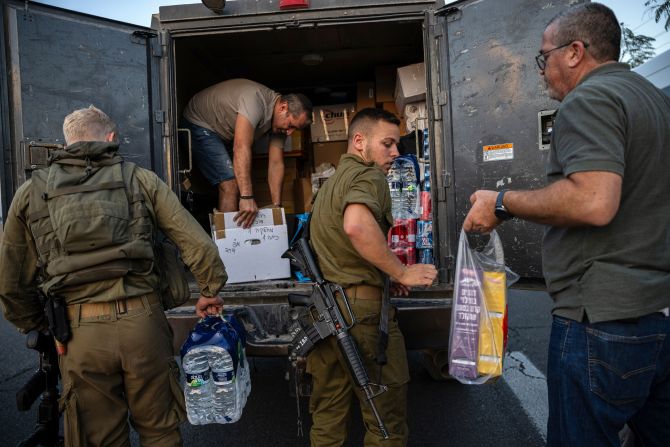 Israeli soldiers load donated food into the back of a military vehicle in Sderot, Israel, on October 11.