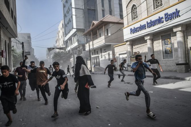 Palestinians run from Israeli airstrikes in Khan Younis, Gaza, on October 11.