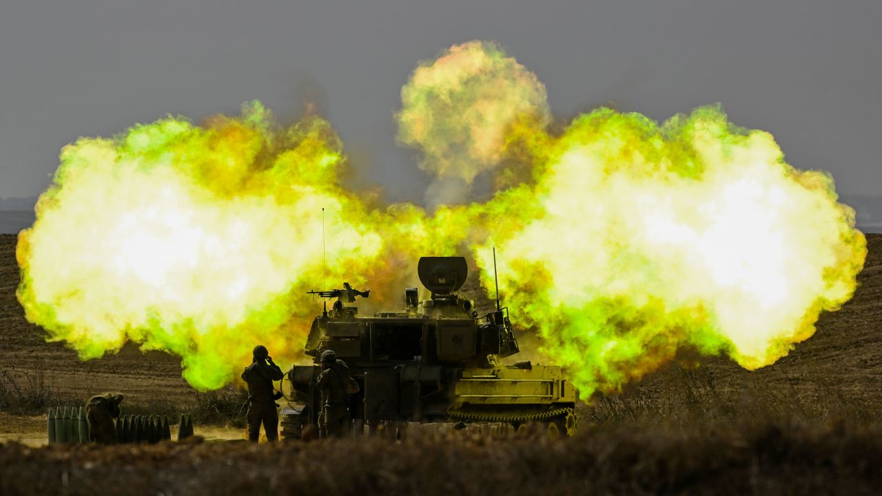 An IDF Artillery solider covers his ears as a shell is fired toward Gaza on October 11, near Netivot, Israel.