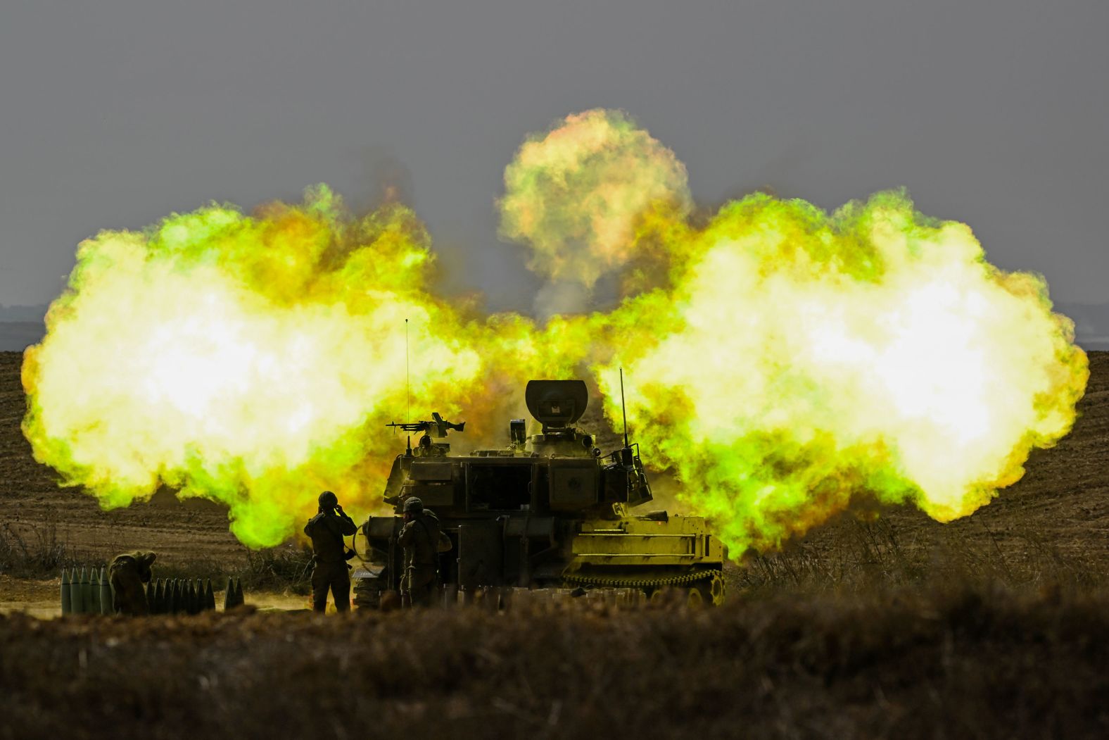An Israeli soldier covers his ears as a shell is fired toward Gaza near Netivot, Israel, on Wednesday, October 11.