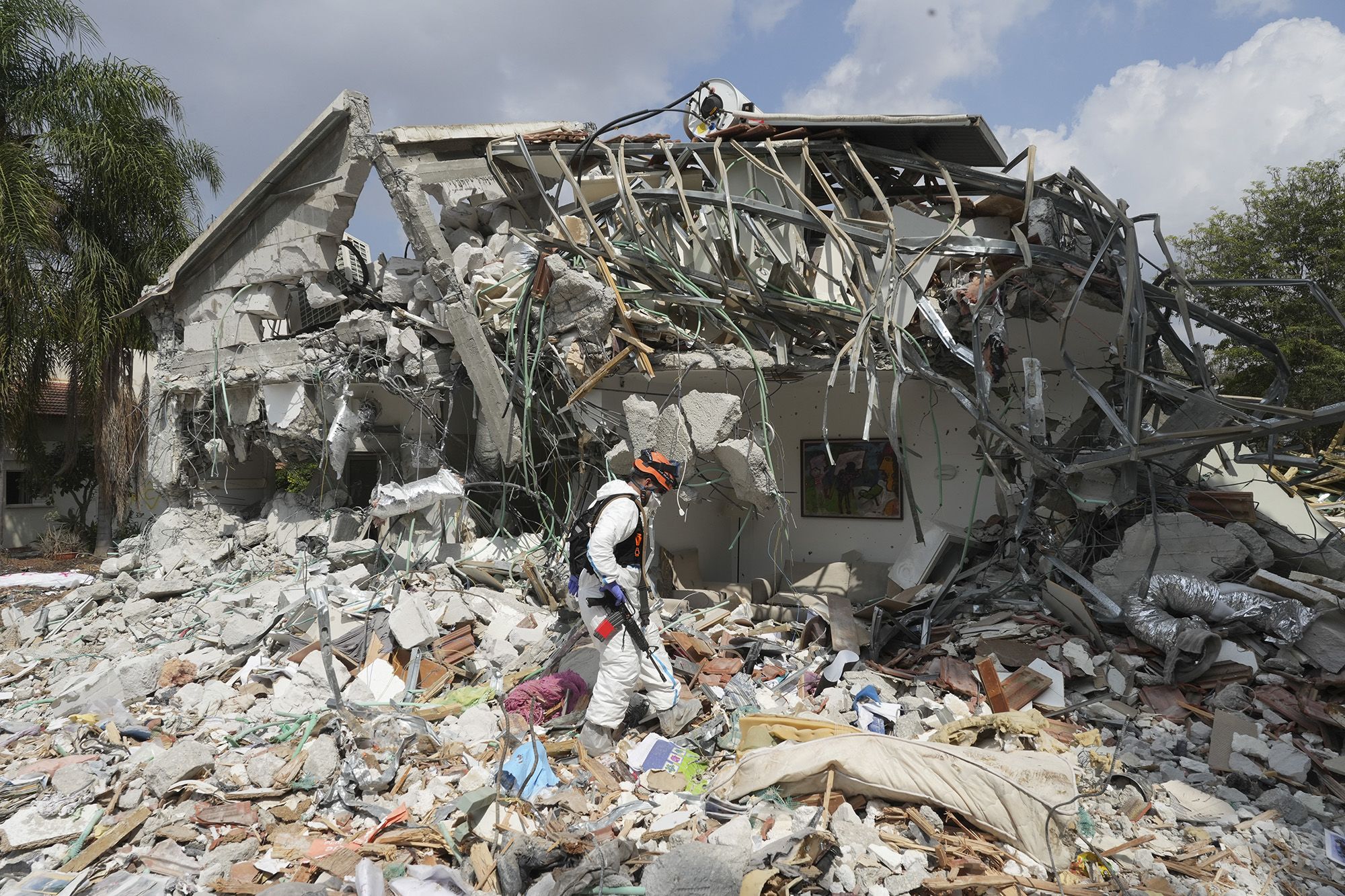 An Israeli soldier walks by a house destroyed by Hamas militants in Kibbutz Be'eri on Wednesday, October 11.