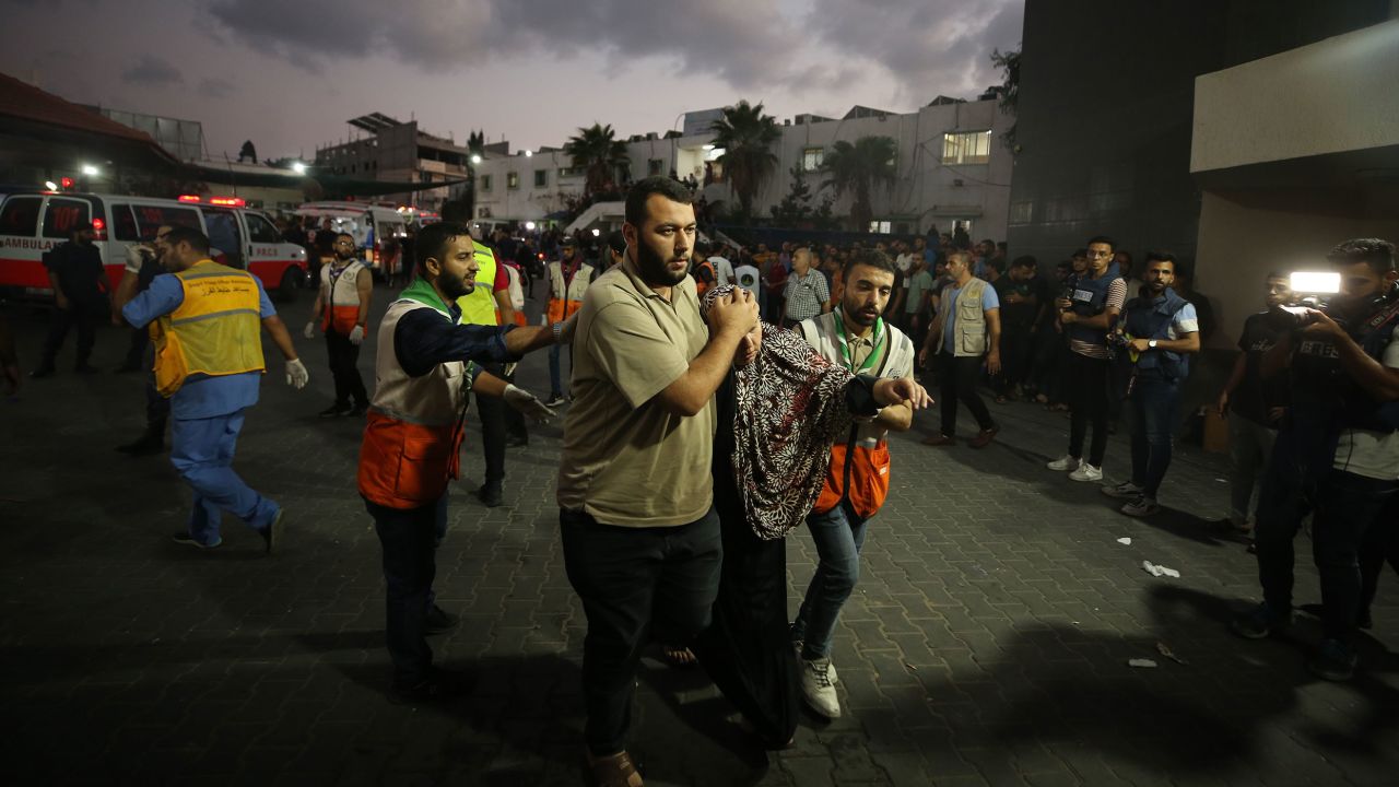 Medical staff carry injured people to Al-Shifa Hospital, in Gaza City, on October 11. Relief workers warned the health care system in Gaza is crumbling under an Israeli blockade.