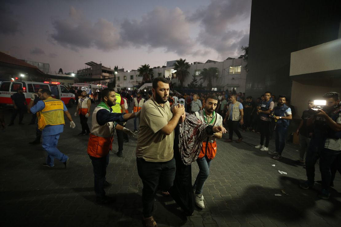 Medical staff carry injured people to Al-Shifa Hospital, in Gaza City, on October 11. Relief workers warned the health care system in Gaza is crumbling under an Israeli blockade.