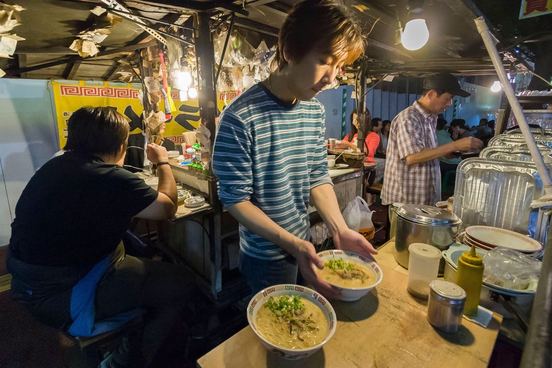 A vendor prepares local Hakata-style pork broth ramen at a Fukuoka yatai.