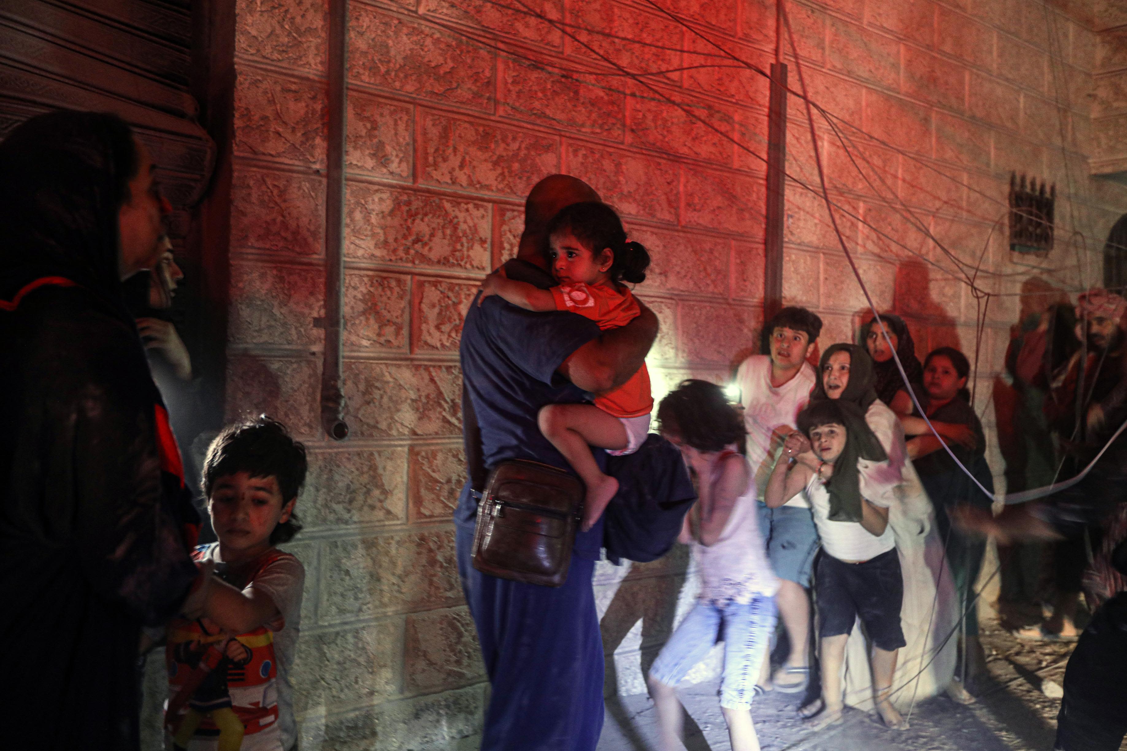 Palestinians seek shelter in Khan Younis, Gaza, after a house next door was hit by an Israeli airstrike on October 12.