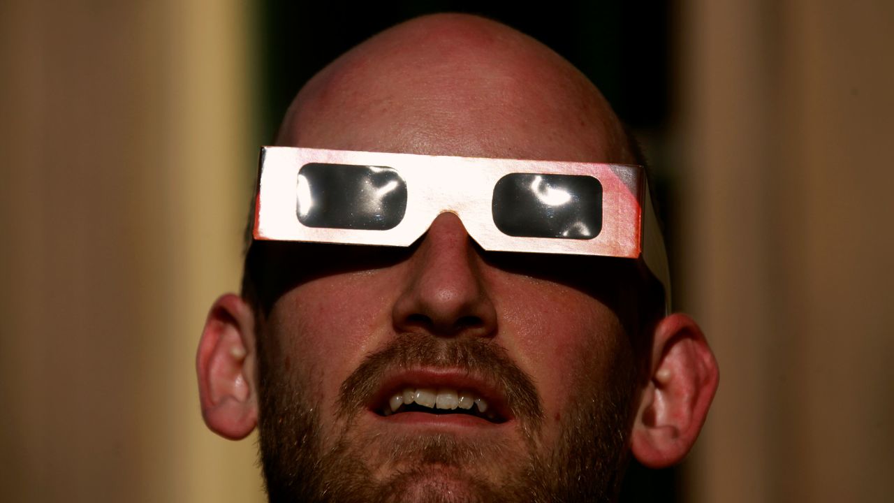 A man wearing protective glasses looks at the annular solar eclipse from atop Observatory Hill in Sydney May 10, 2013.   REUTERS/David Gray     (AUSTRALIA - Tags: ENVIRONMENT)
