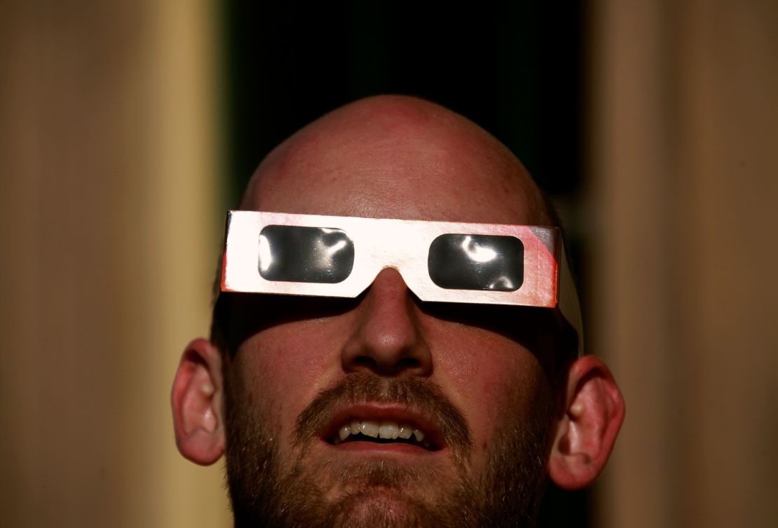A man wearing protective glasses looks at the annular solar eclipse from atop Observatory Hill in Sydney May 10, 2013.   REUTERS/David Gray     (AUSTRALIA - Tags: ENVIRONMENT)