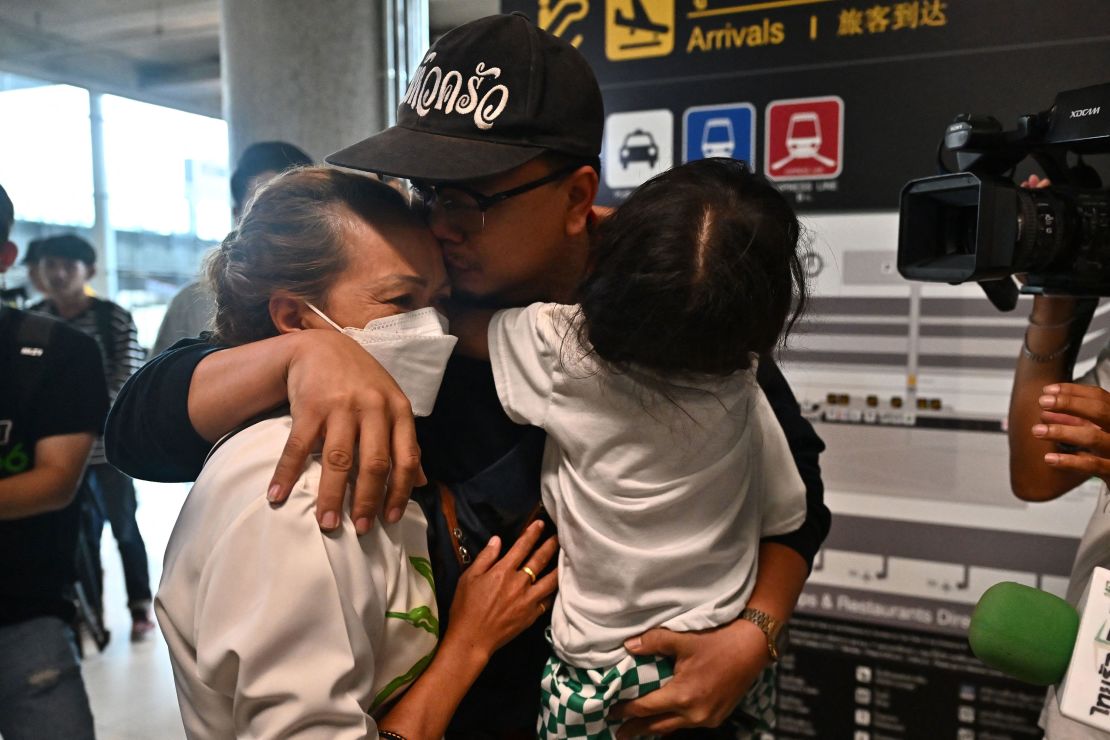 A Thai national (C) hugs family members after arriving on a flight from Israel at Suvarnabhumi International Airport in Bangkok on October 12, 2023, as Thais working in Israel returned to the kingdom following a surprise attack on Israel by the Palestinian militant group Hamas. Thailand's prime minister announced on October 12 the death toll of Thai nationals killed in the conflict between Israel and militant group Hamas had risen to 21, as worried families gathered at a Bangkok airport to be reunited with wounded loved ones. (Photo by Lillian SUWANRUMPHA / AFP) (Photo by LILLIAN SUWANRUMPHA/AFP via Getty Images)