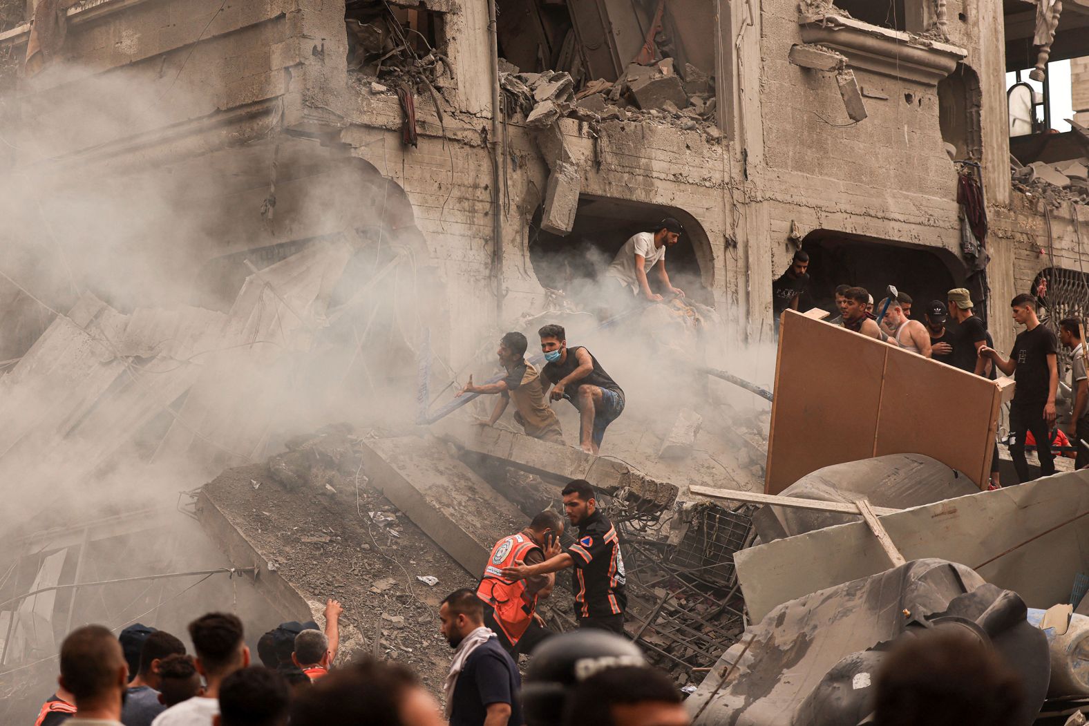 Palestinians search for survivors after an Israeli airstrike at the Jabalia refugee camp in Gaza City on Monday, October 9.