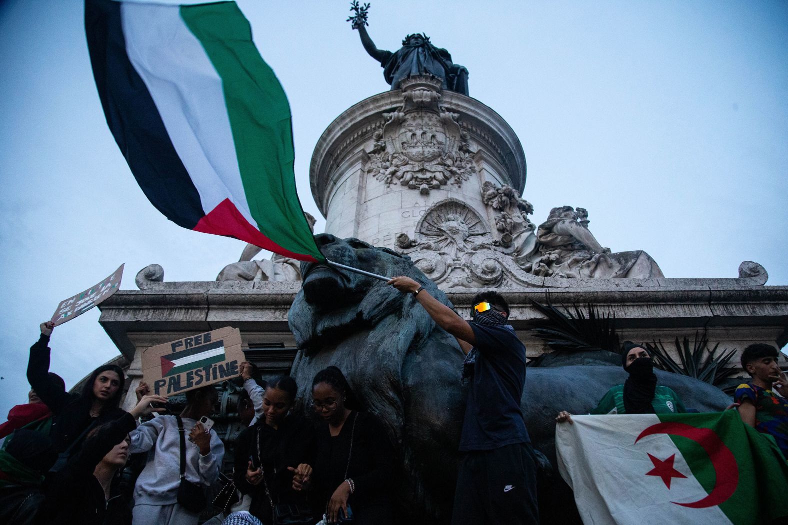 Demonstrators climb up the Monument à la République in Paris during a pro-Palestinian rally on Thursday, October 12.