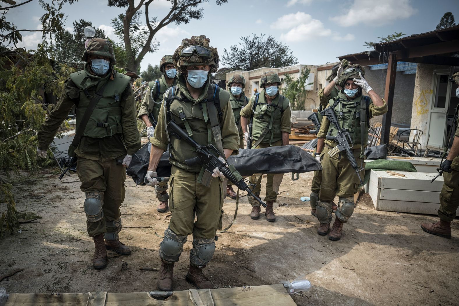 Israeli soldiers carry a body in Kfar Aza, Israel, on Tuesday, October 10. Hamas militants carried out a "massacre" in Kfar Aza during their attacks over the weekend, <a href="index.php?page=&url=https%3A%2F%2Fwww.cnn.com%2Fmiddleeast%2Flive-news%2Fisrael-hamas-war-gaza-10-10-23%2Fh_7867b7563e54a0b29dddeada7e4c2722" target="_blank">the Israel Defense Forces told CNN</a>.