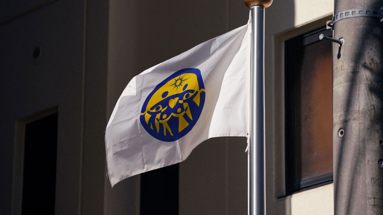 The flag of the Family Federation for World Peace and Unification (FFWPU), known as the Unification Church, is seen at the entrnace of its Japan branch headquarters in Tokyo on October 13, 2023. The Japanese government said on October 12 it was seeking to strip official recognition from the Unification Church, the influential sect under intense scrutiny since the assassination of former prime minister Shinzo Abe. (Photo by Kazuhiro NOGI / AFP) (Photo by KAZUHIRO NOGI/AFP via Getty Images)