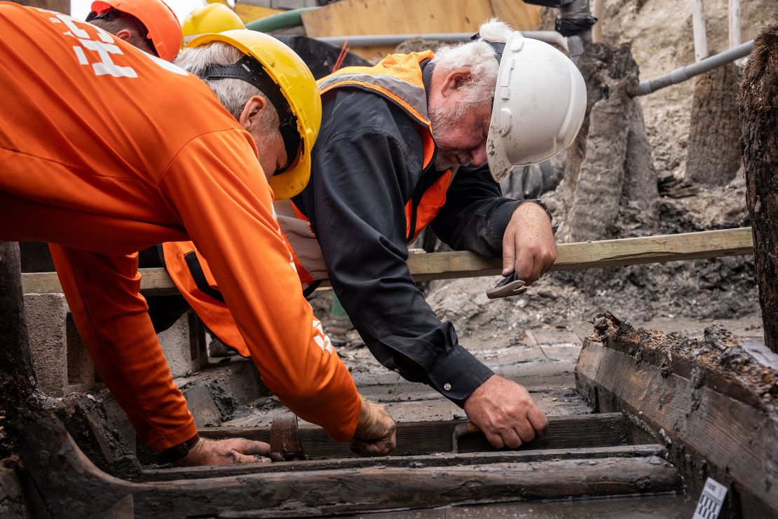 Archaeologists Dr. Sam Turner (left) and Dr.
James Delgado slide a bottom rib from its socket in the centerboard trunk of the ship.