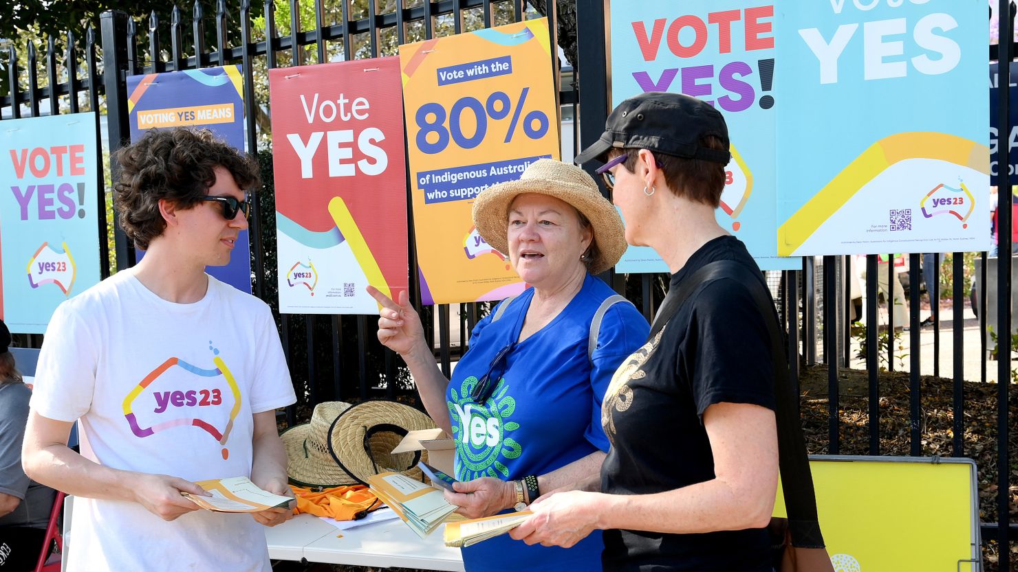 A vote talks to 'Yes' voting campaigners at a polling center at Brisbane State High School on October 14, 2023.